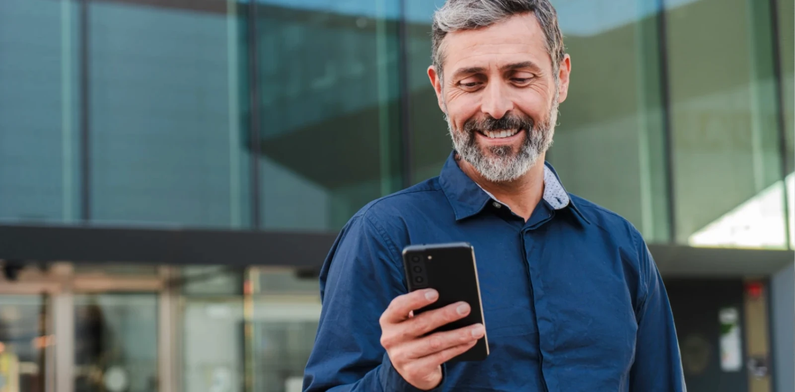 mature man using his smartphone without glasses