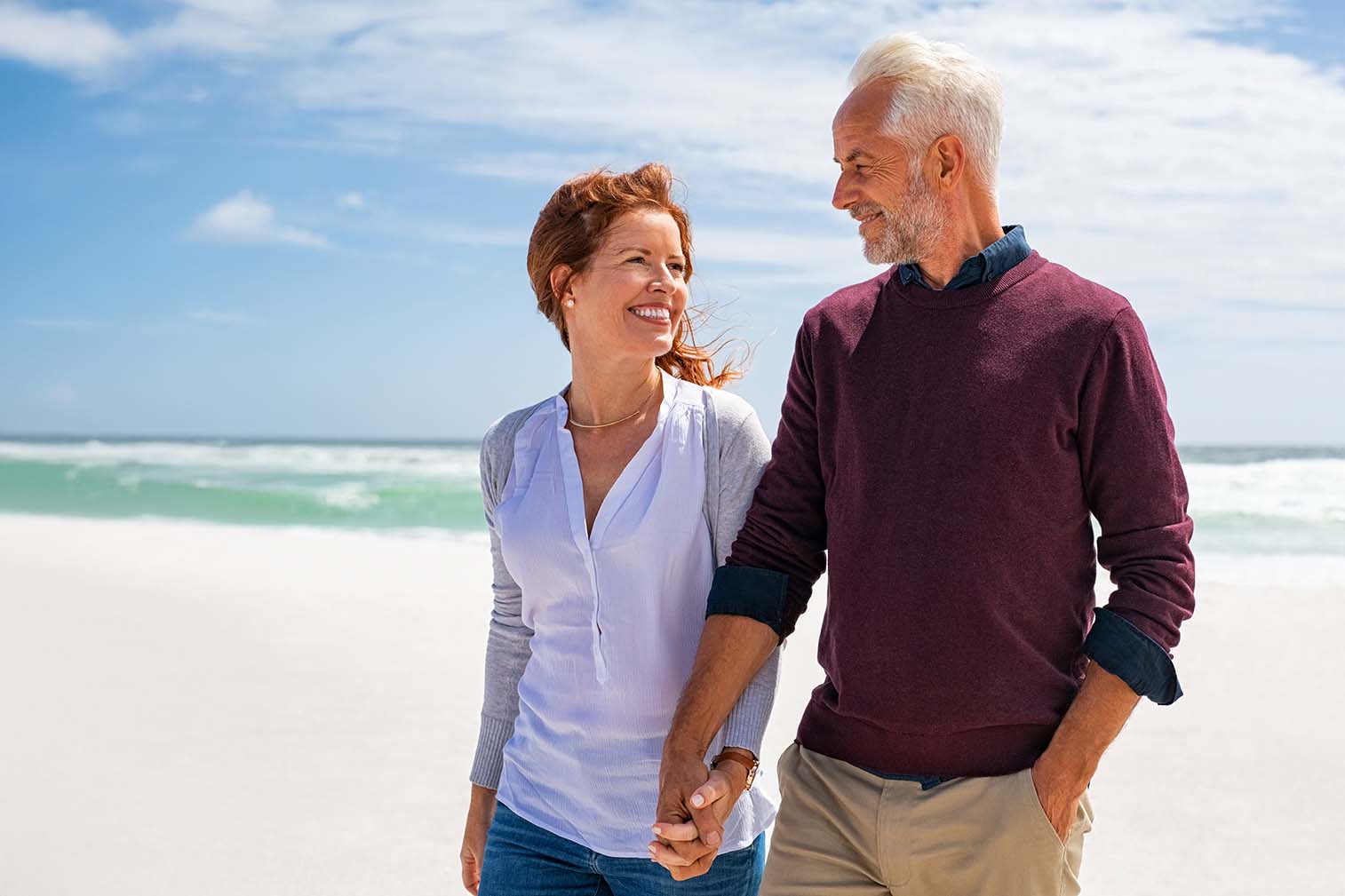 middle aged couple smiling while at the beach