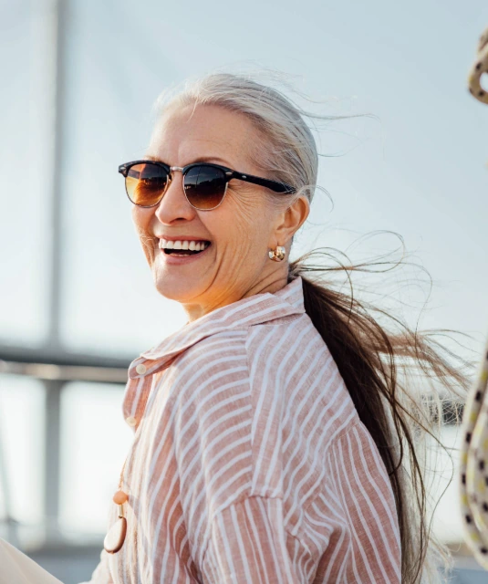 happy senior woman on boat wearing sunglasses