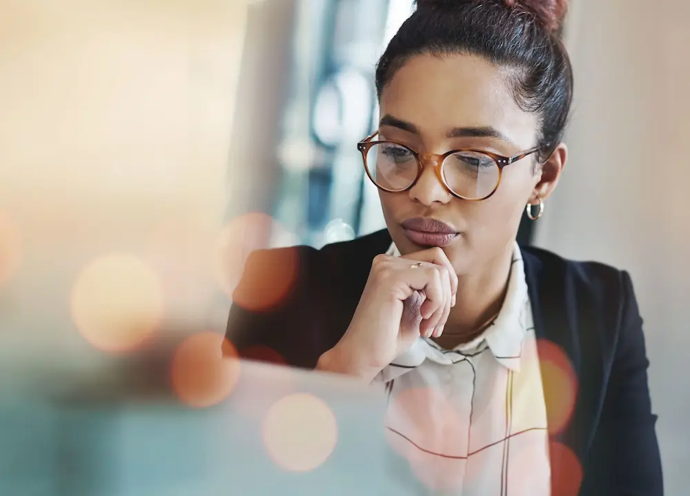 woman with glasses researching vision procedures on her laptop
